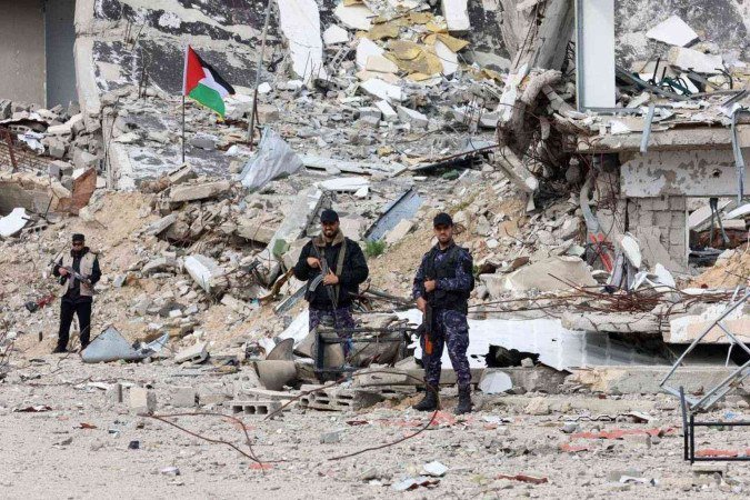 
Membros das forças de segurança palestinas leais ao Hamas montam guarda em frente a um complexo policial destruído na Cidade de Gaza, em 22 de janeiro de 2025, no quarto dia do acordo de cessar-fogo na guerra entre Israel e o Hamas no território palestino.  -  (crédito:  AFP)