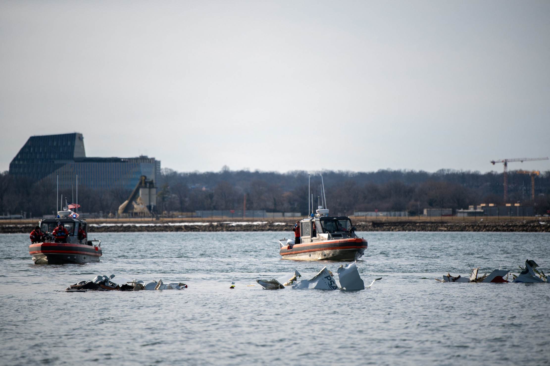 Botes da Guarda Costeira dos EUA diante de destroos do avio a jato no Rio Potomac, na capital norte-americana 