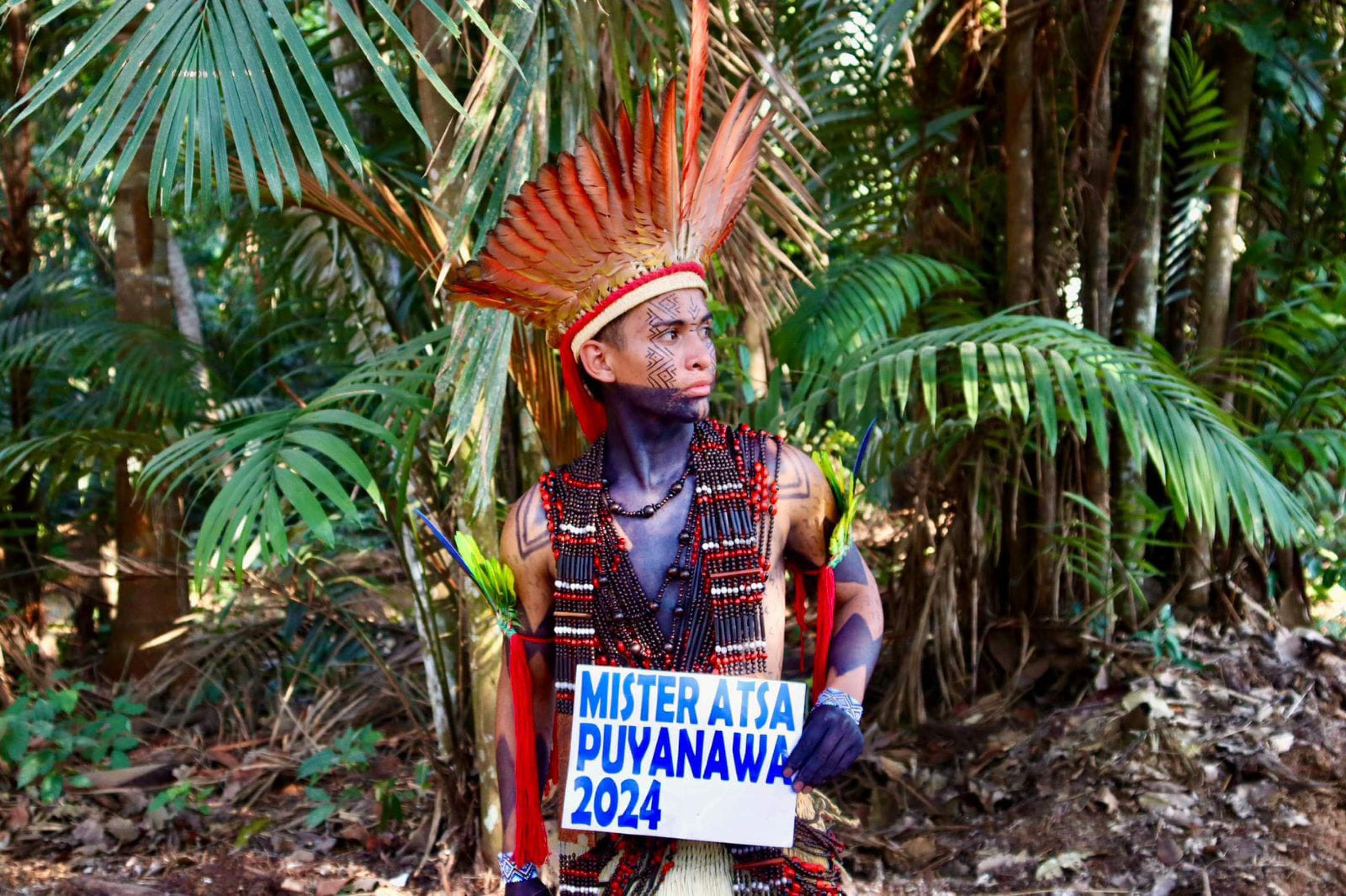 Gulherme Puyanawa segura cartaz que, em sua comunidade, indica um exemplo a ser seguido