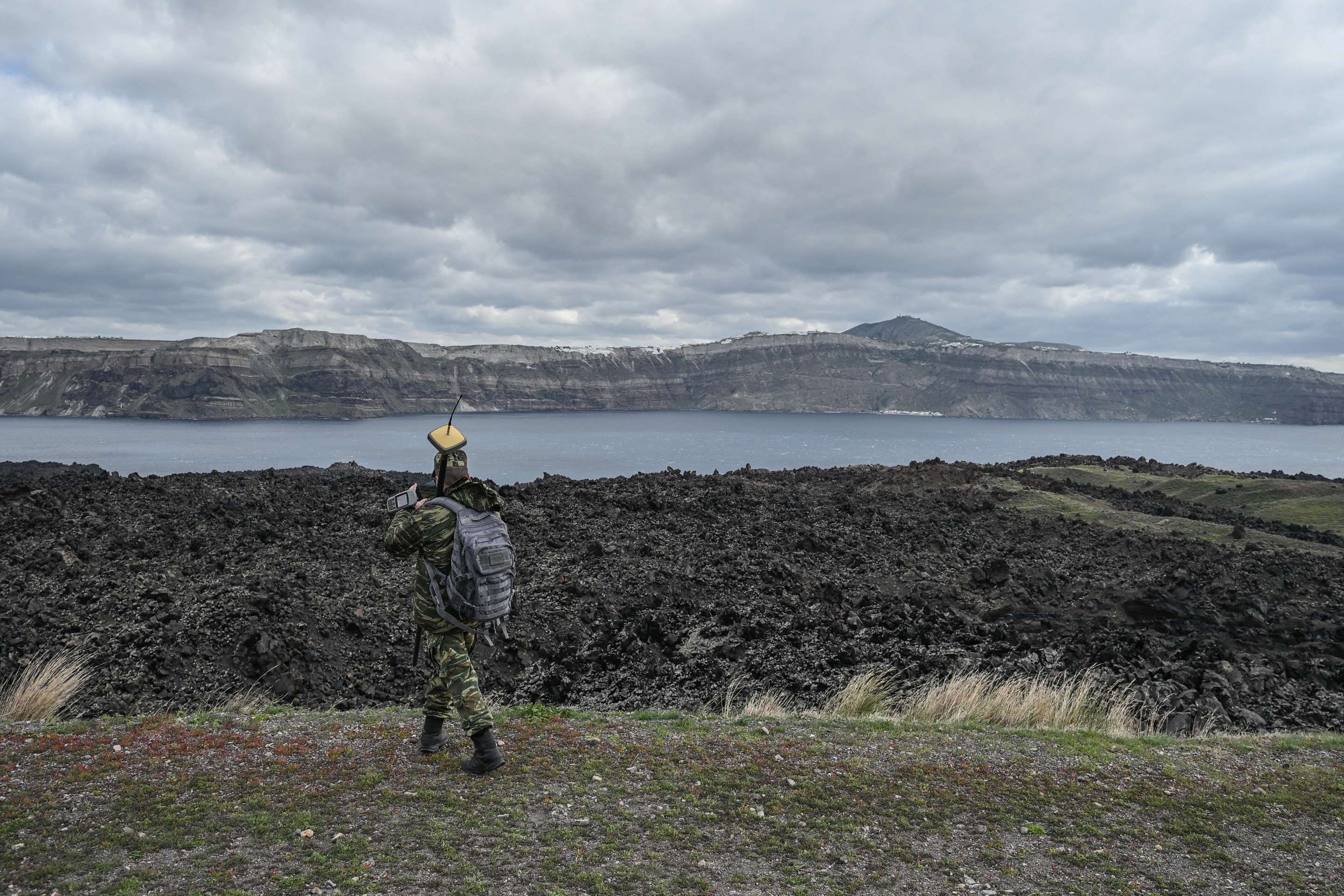 Membro do serviço geográfico militar grego fazem medições na ilha vulcânica de Santorini, Nea Kameni, para determinar se os tremores causaram alguma mudança estrutural                  