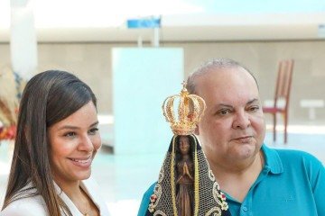 Em momento de fé, o casal carrega imagem de Nossa Senhora Aparecida