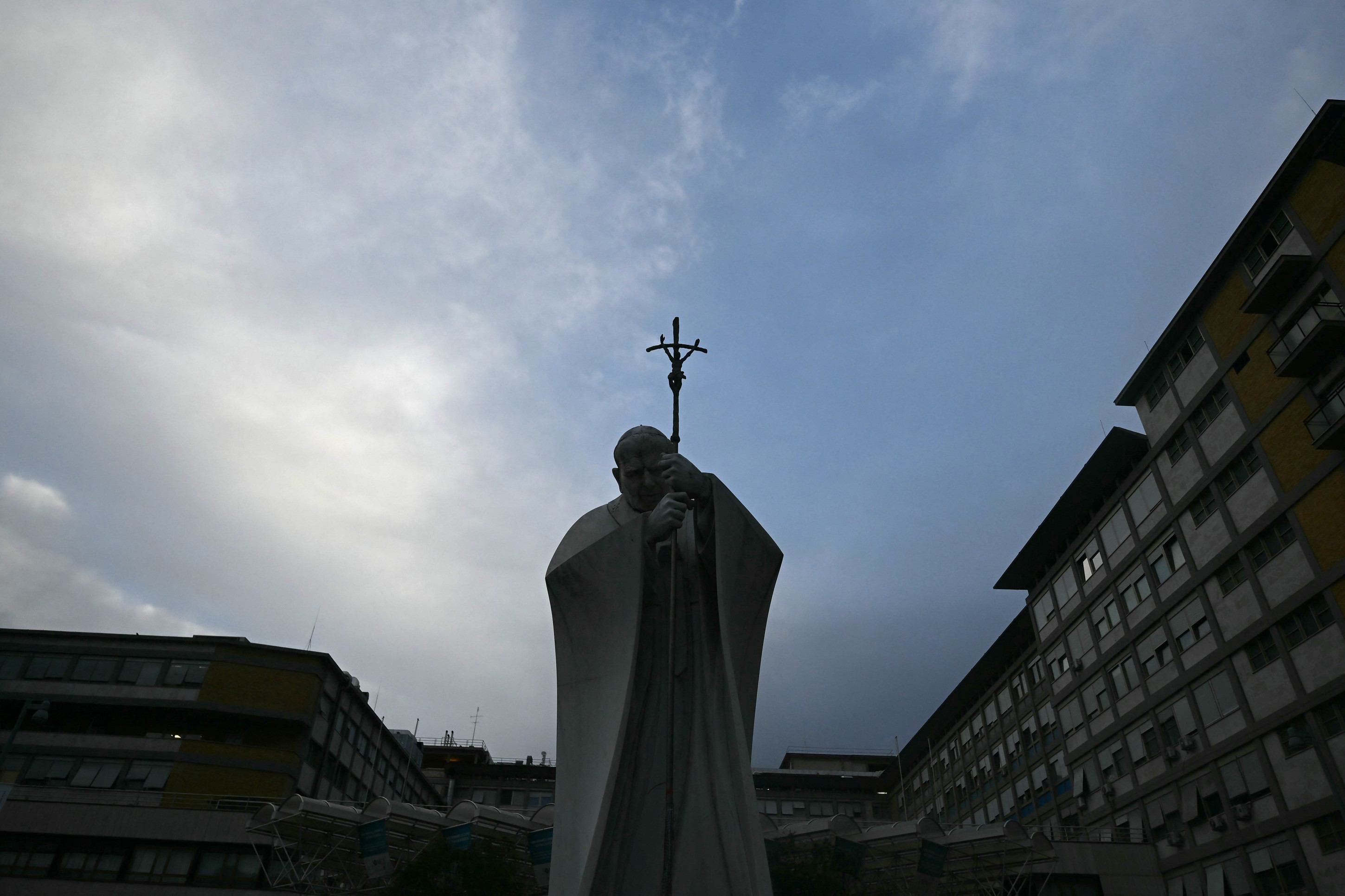 Fiéis fazem uma corrente de oração e acendem velas aos pés da estátua do Papa João Paulo II, localizada em frente o hospital                   