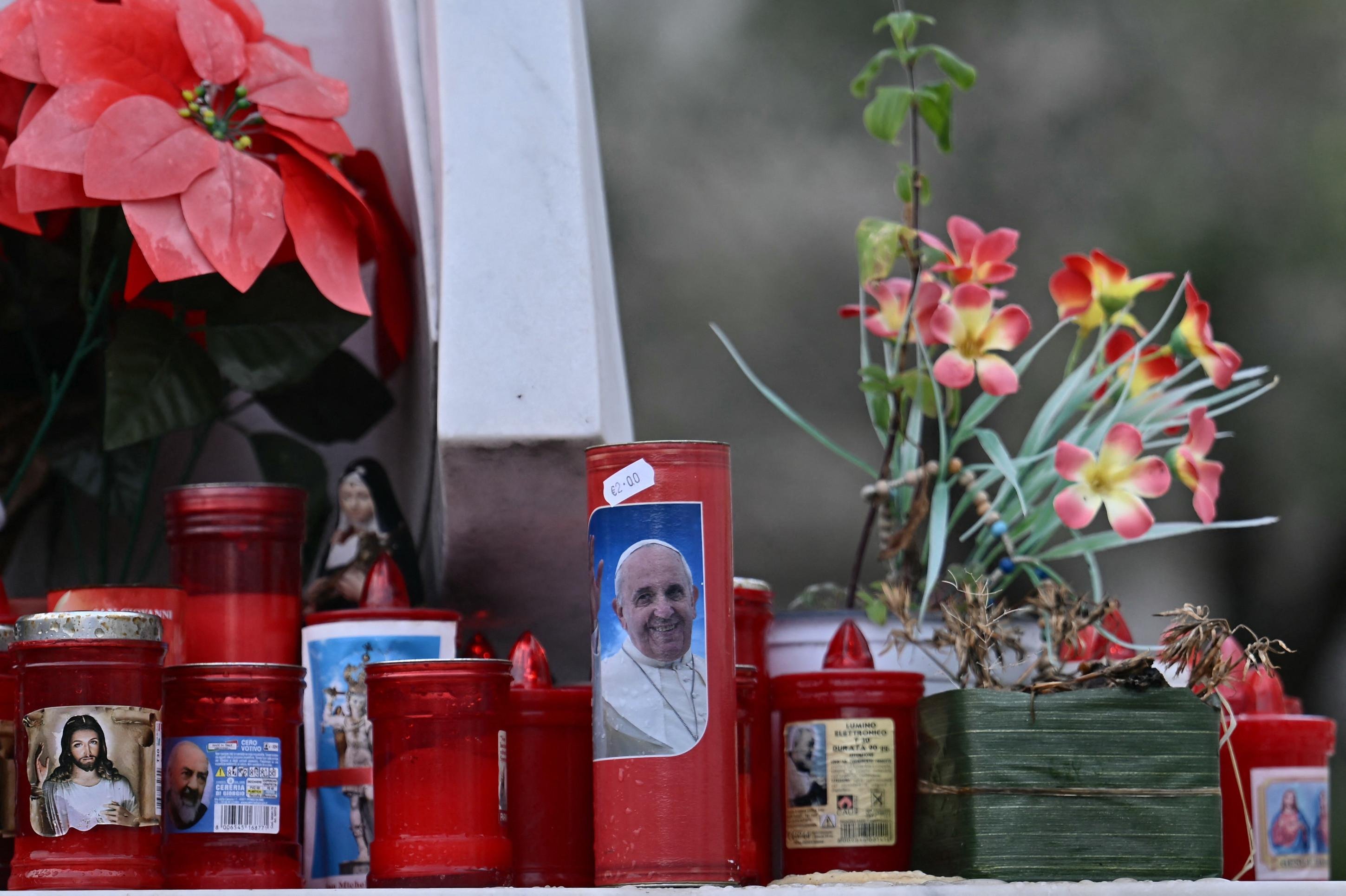 Fiéis fazem uma corrente de oração e acendem velas aos pés da estátua do Papa João Paulo II, localizada em frente o hospital                   
