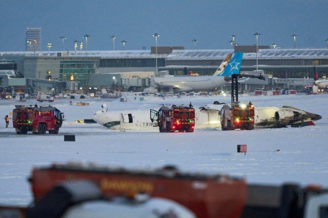 Um avião da Delta Airlines fica no teto após cair ao pousar no Aeroporto Toronto Pearson, em Toronto, Ontário, em 17 de fevereiro de 2025      