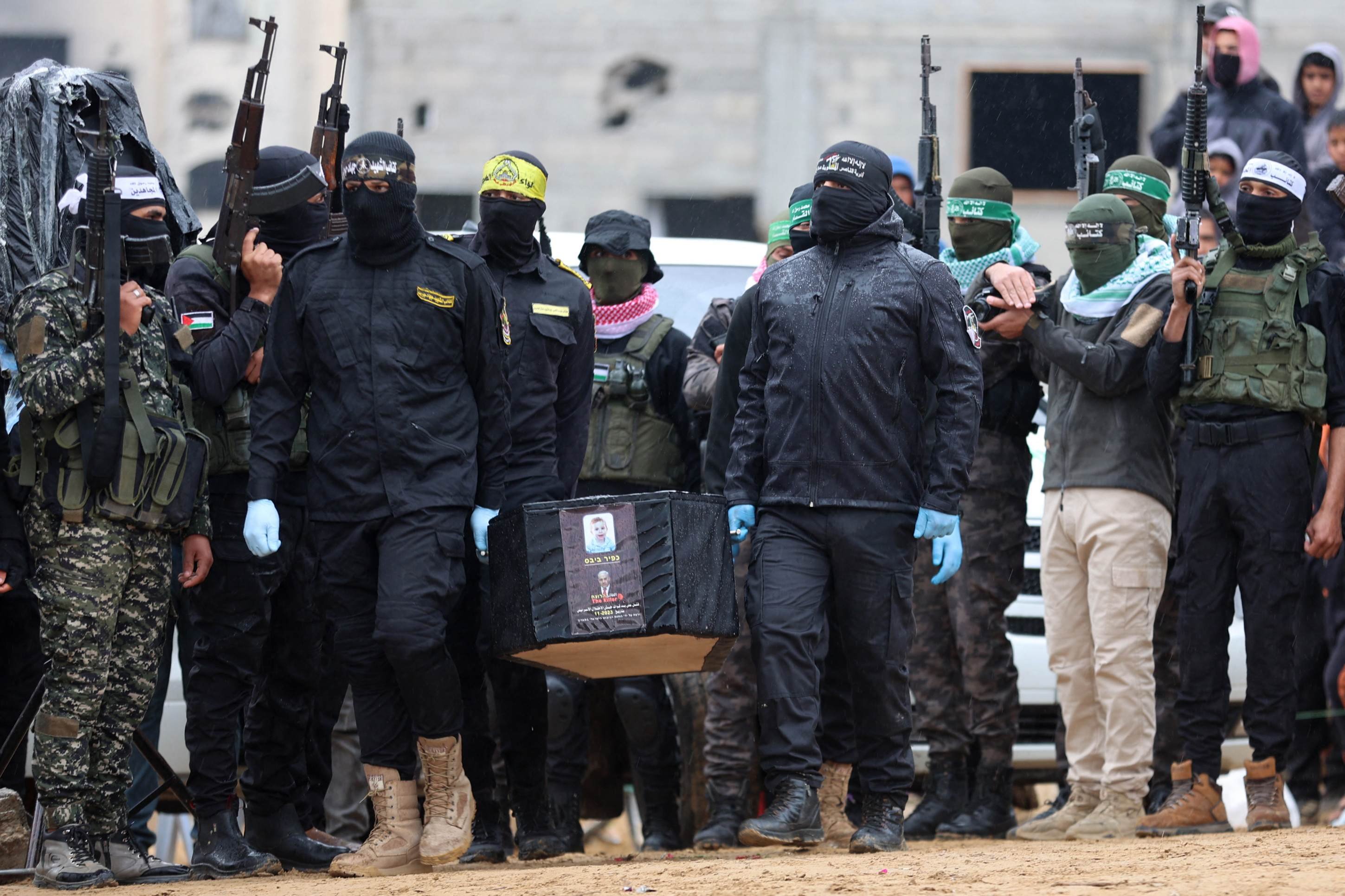 Militantes palestinos carregam um dos quatro caixões durante a entrega dos corpos de quatro reféns israelenses à Cruz Vermelha em Khan Yunis, no sul de Gaza, em 20 de fevereiro de 2025      