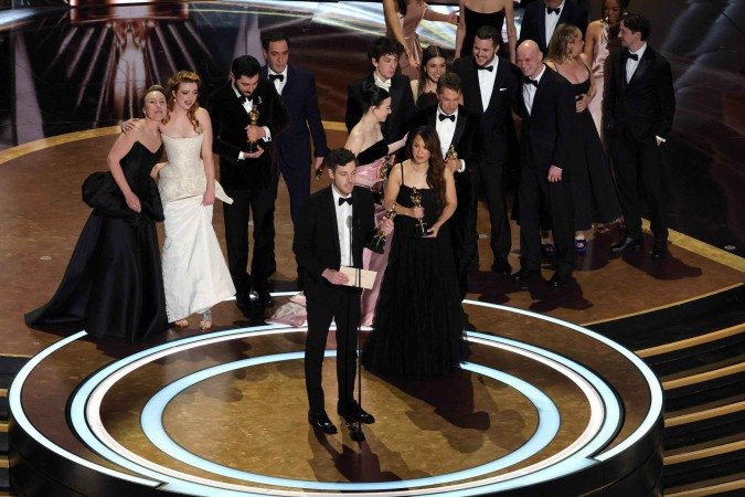 Elenco e equipe incluindo Darya Ekamasova, Lindsey Normington, Vache Tovmasyan, Karren Karagulian, Alex Coco, Mikey Madison, Mark Eydelshteyn, Samantha Quan, Luna Sofía Miranda, Sean Baker, Drew Daniels e Yura Borisov recebem o prêmio de Melhor Filme por 