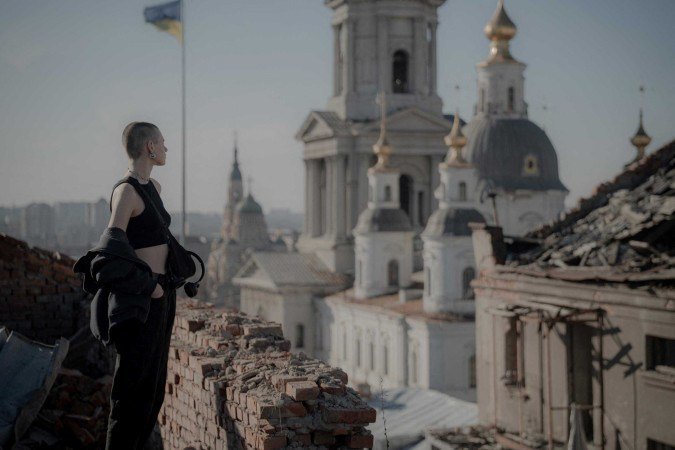  Valentyna Guk stands on a roof of a heavily damaged building in the downtown of Kharkiv on March 7, 2025, amid the Russia invasion of Ukraine. Valentyna Guk is a 21-year-old Ukrainian artist from Kharkiv who creates mosaics from broken glass. After the shelling, Valentyna collects interestingly shaped pieces of glass and then assembles them into separate mosaic forms, which she later hangs on the facades of buildings. In total, there are six of her mosaic works on the streets of Kharkiv and one in Izyum. (Photo by Ivan SAMOILOV / AFP)
      
