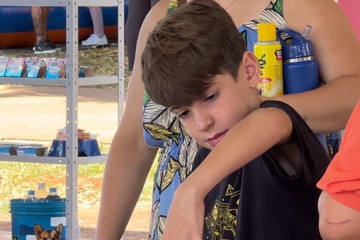 Igor Araújo, 10, brincando com os cachorros para adoção no Carnapati