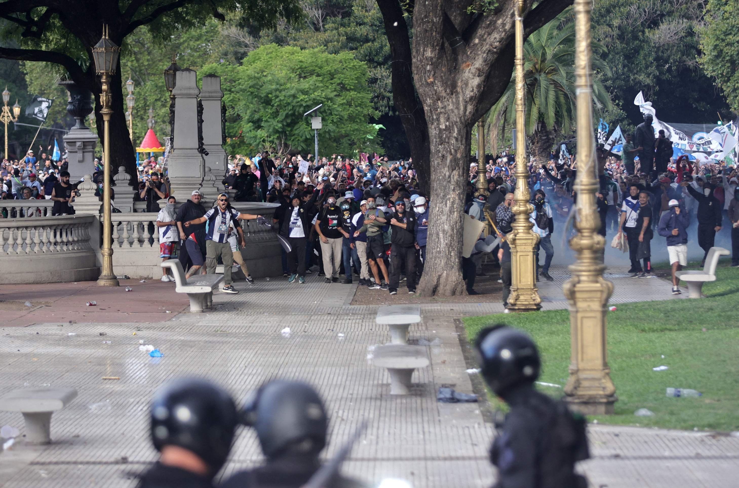 Demonstrators clash with riot police during a protest of pensioners supported by football fans against the government of President Javier Milei in Buenos Aires on March 12, 2025. (Photo by Emiliano Lasalvia / AFP)       