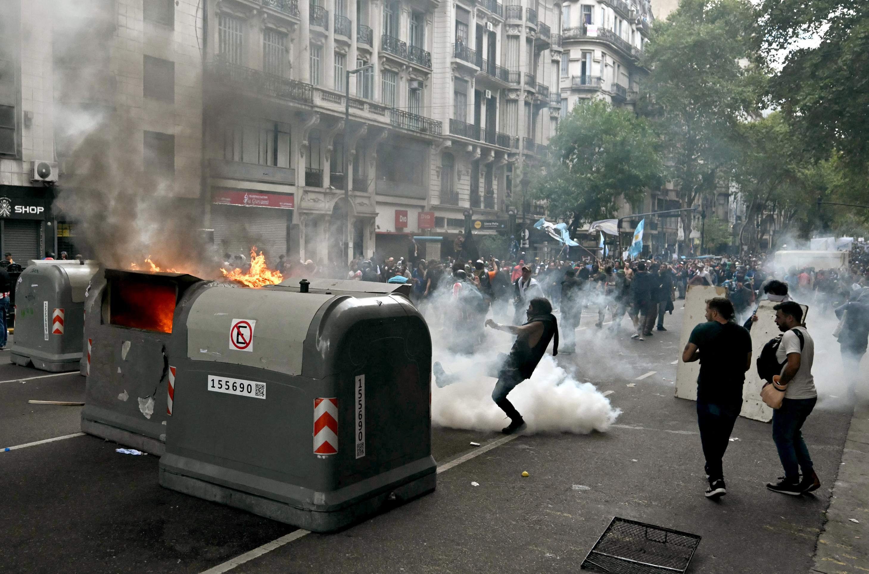  Football fans set garbage containers on fire during a protest of pensioners against the government of President Javier Milei in Buenos Aires on March 12, 2025. (Photo by Luis ROBAYO / AFP)       