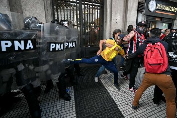  A supporter of Rosario Central clashes with police during a protest of pensioners supported by football fans against the government of President Javier Milei in Buenos Aires on March 12, 2025. (Photo by Luis ROBAYO / AFP)        -  (crédito:  AFP)