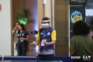 Visitantes testam o experimentam o tênis de mesa com óculos de realidade virtual
