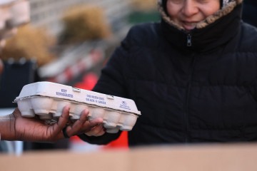 Pessoas recebem uma dúzia de ovos durante uma doação gratuita de ovos em frente ao Brown Butter Craft Bar & Kitchen em 21 de março de 2025 na cidade de Nova York.  -  (crédito: Michael M. Santiago / GETTY IMAGES NORTH AMERICA / Getty Images via AFP)