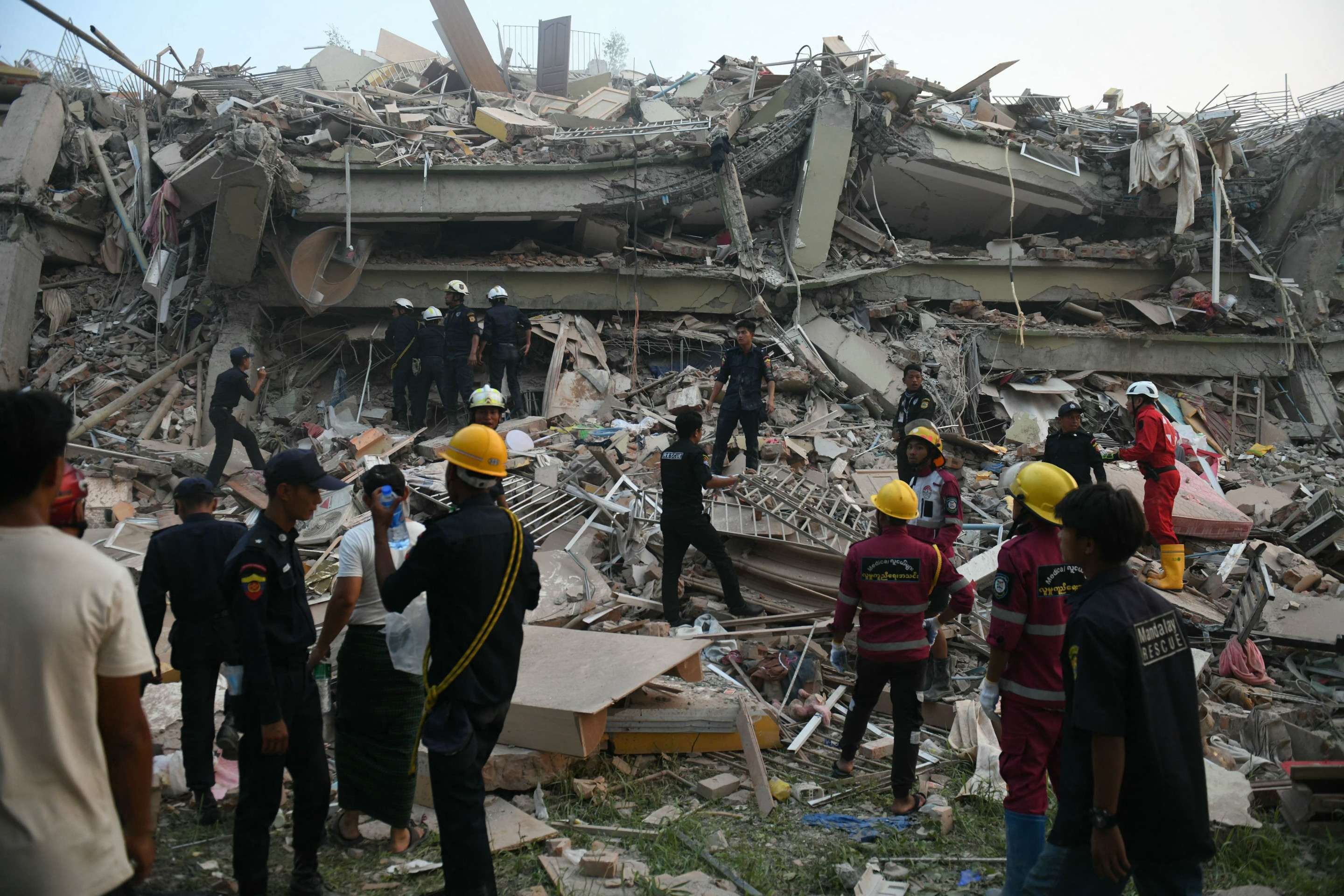  Equipes de resgate buscam sobreviventes presos no prédio desabado do Sky Villa Condominium em Mandalay em 29 de março de 2025, um dia após um terremoto atingir o centro de Mianmar. Equipes de resgate retiraram uma mulher viva dos destroços de um prédio de apartamentos desabado em Mandalay em 29 de março, jornalistas da AFP viram, 30 horas após um terremoto devastador atingir Mianmar. (Foto de Sai Aung MAIN / AFP)       