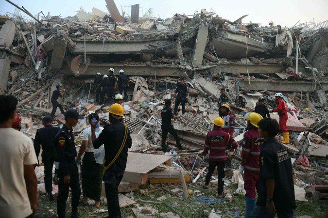  Equipes de resgate buscam sobreviventes presos no prédio desabado do Sky Villa Condominium em Mandalay em 29 de março de 2025, um dia após um terremoto atingir o centro de Mianmar. Equipes de resgate retiraram uma mulher viva dos destroços de um prédio de apartamentos desabado em Mandalay em 29 de março, jornalistas da AFP viram, 30 horas após um terremoto devastador atingir Mianmar. (Foto de Sai Aung MAIN / AFP)       