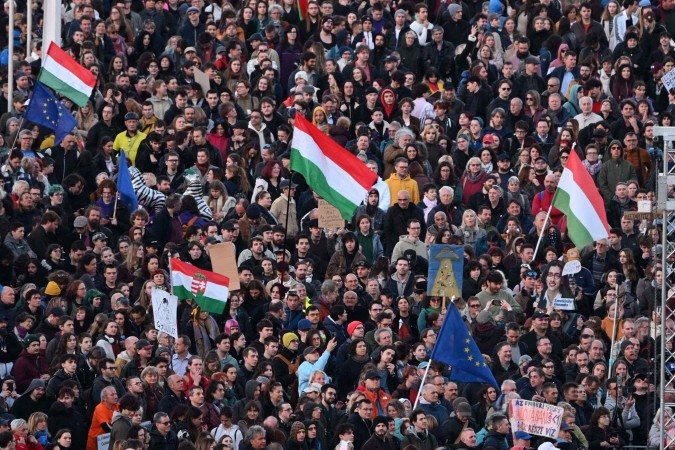 Manifestantes participam de um comício na Ponte Erzsebet (Elisabet) em Budapeste em 1º de abril de 2025 contra os esforços do governo para restringir a liberdade de reunião e expandir seus poderes de vigilância. Os legisladores húngaros aprovaram uma legislação em 18 de março de 2025 com o objetivo de proibir a marcha anual do Orgulho e outras manifestações, permitindo o uso de ferramentas de reconhecimento facial para identificar participantes de manifestações proibidas - (crédito: AFP) Manifestantes participam de um comício na Ponte Erzsebet (Elisabet) em Budapeste em 1º de abril de 2025 contra os esforços do governo para restringir a liberdade de reunião e expandir seus poderes de vigilância. Os legisladores húngaros aprovaram uma legislação em 18 de março de 2025 com o objetivo de proibir a marcha anual do Orgulho e outras manifestações, permitindo o uso de ferramentas de reconhecimento facial para identificar participantes de manifestações proibidas - (crédito: AFP)