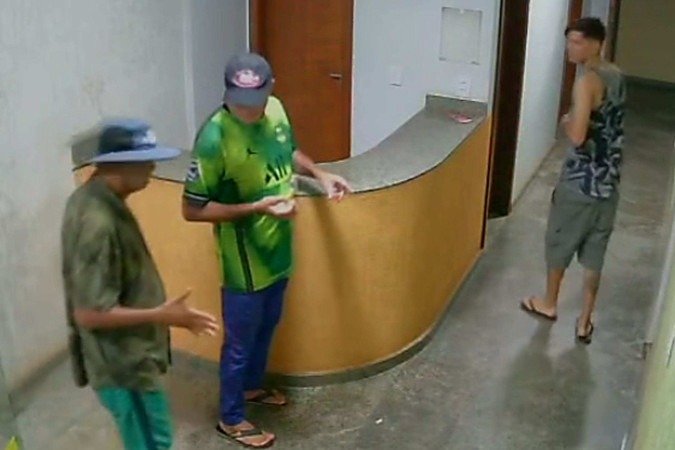 Câmera de segurança do prédio registrou a entrada dos dois assassinos com a vítima (de chapéu), por volta de 3h40 de sexta-feira