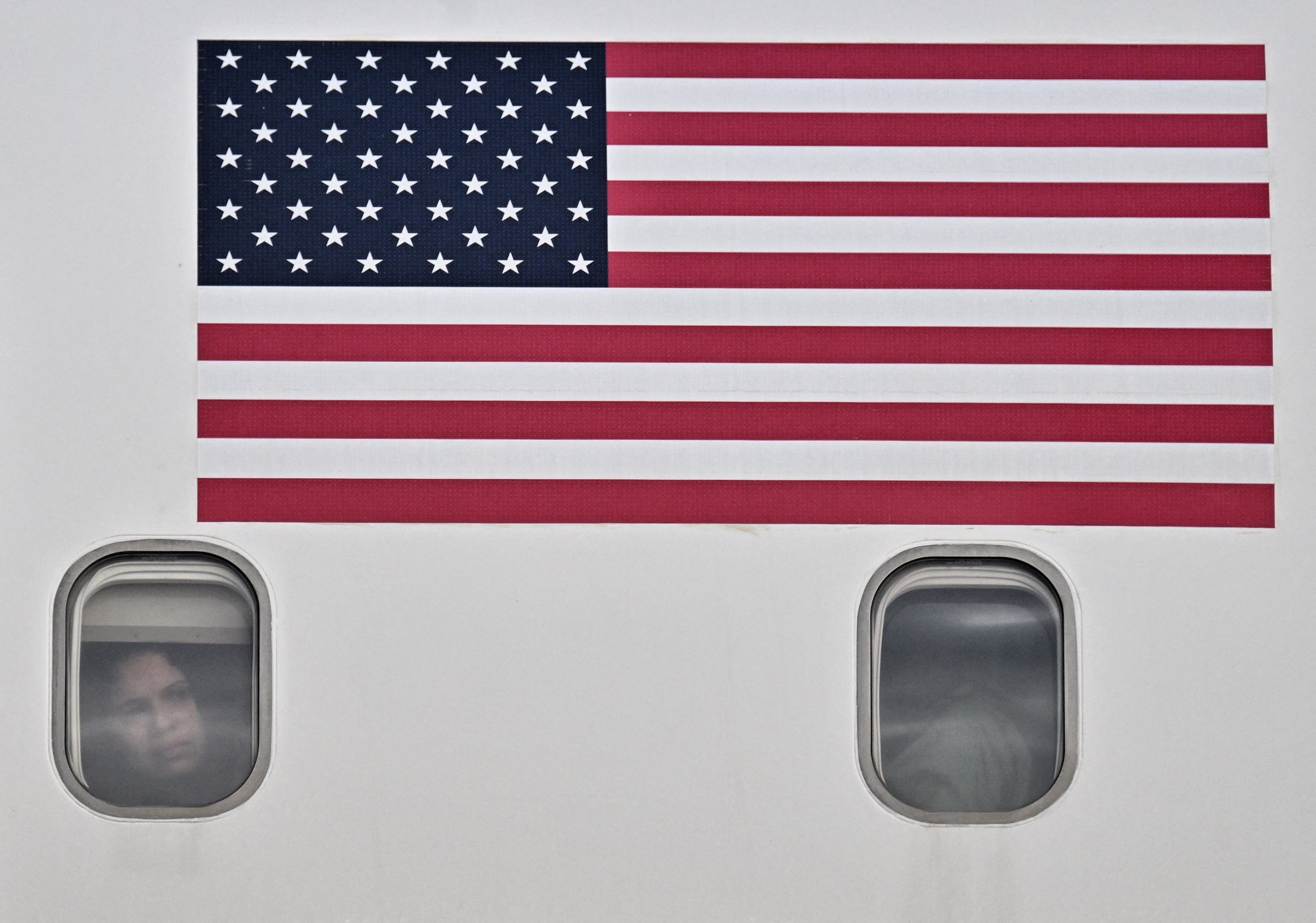 Migrante venezuelano repatriado dos EUA olha pela janela do avi&atilde;o ap&oacute;s aterrissagem em Caracas