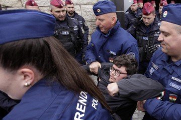 Policiais removem manifestante durante protesto que bloqueou a entrada do prédio do Parlamento 