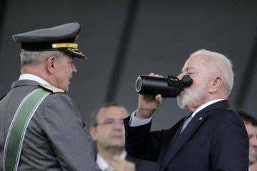  Brazil's President Luiz Inacio Lula da Silva (R) drinks from a bottle next to Army Commander General Tomas Paiva during the Army Day celebration at the Army Headquarters in Brasilia on April 16, 2025. (Photo by Sergio Lima / AFP)
       -  (crédito:  AFP)