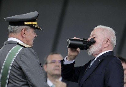  Brazil's President Luiz Inacio Lula da Silva (R) drinks from a bottle next to Army Commander General Tomas Paiva during the Army Day celebration at the Army Headquarters in Brasilia on April 16, 2025. (Photo by Sergio Lima / AFP)
       -  (crédito:  AFP)