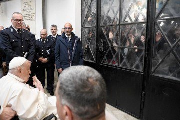 Francisco conversa com presos, por trás de uma vidraça, no Regina Coeli -  (crédito: Imprensa do Vaticano/AFP)