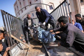 Pessoas transportam da caçamba de um caminhão os restos mortais de uma vítima do bombardeio israelense em Jabalia, no Hospital Indonésio em Beit Lahia, no norte da Faixa de Gaza, em 18 de abril de 2025. A agência de defesa civil de Gaza informou em 18 de abril que 15 pessoas, incluindo 10 da mesma família, foram mortas em dois ataques noturnos, enquanto Israel prosseguia com sua implacável ofensiva militar no território palestino.       -  (crédito: BASHAR TALEB / AFP)