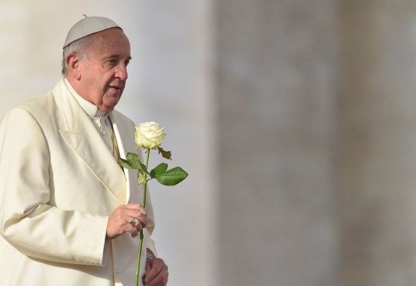 O Papa Francisco leva uma rosa branca à Virgem Maria durante sua audiência geral semanal na Praça de São Pedro, no Vaticano, em 9 de dezembro de 2015       -  (crédito: Vincenzo Pinto / AFP)