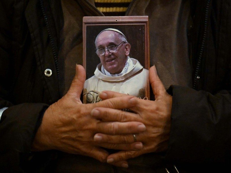 Fiel abraça o retrato de Francisco durante missa na Basílica San Jose de Flores, em Buenos Aires  -  (crédito: Luis Robayo/AFP)
