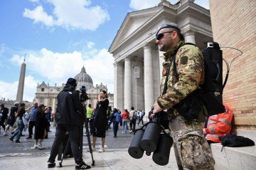 Militar italiano, com arma antidrone, de prontidão: 2 mil policiais mobilizados na região do Vaticano
- (crédito: AFP) Militar italiano, com arma antidrone, de prontidão: 2 mil policiais mobilizados na região do Vaticano
- (crédito: AFP)