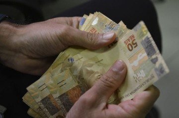 Notas de dinheiro em mãos -  (crédito: Marcelo Casal Jr/Agência Brasil)