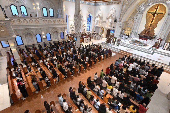Pessoas assistem a uma missa para o Papa Francisco na Igreja Católica Catedral de Denpasar, na ilha turística de Bali, na Indonésia, em 26 de abril de 2025      