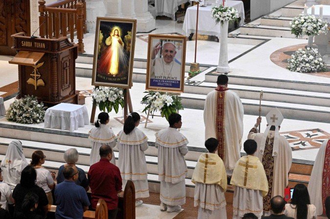 Pessoas assistem a uma missa para o Papa Francisco na Igreja Católica Catedral de Denpasar, na ilha turística de Bali, na Indonésia, em 26 de abril de 2025      