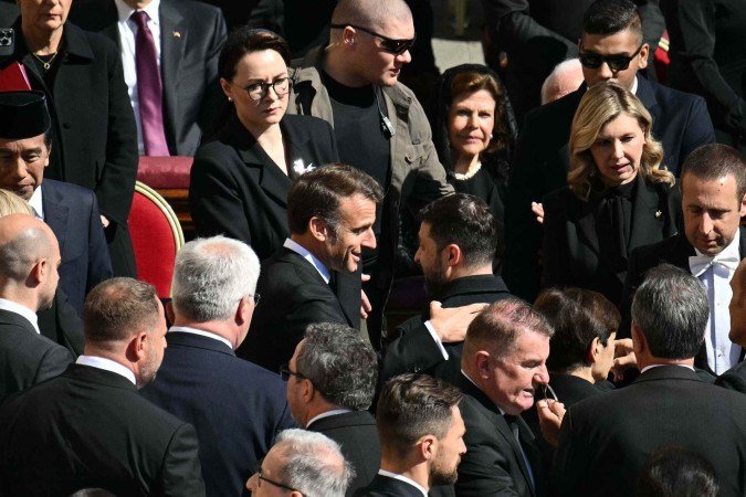 O presidente francÃªs, Emmanuel Macron (C), e o presidente ucraniano, Volodymyr Zelensky, se cumprimentam ao chegarem antes da cerimÃŽnia fÃºnebre do Papa Francisco na PraÃ§a de SÃ£o Pedro, no Vaticano, em 26 de abril de 2025      