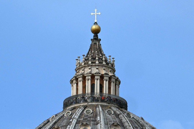 Fiéis e peregrinos se reúnem na Praça de São Pedro após a morte do Papa Francisco no Vaticano em 21 de abril de 2025      