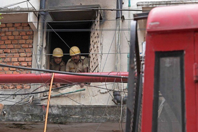  Firefighters inspect the Rituraj Hotel where a fire brokeout, in Kolkata on April 30, 2025. A fierce fire ripped through a hotel in the Indian city of Kolkata killing at least 15 people, police said on April 30, with some clambering out of windows and onto the rooftop to escape. (Photo by Dibyangshu SARKAR / AFP)       Caption 