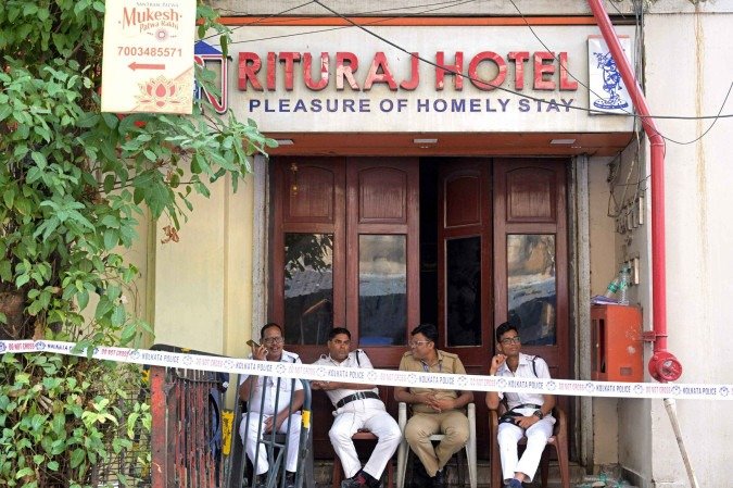  Police officials guard the entrance of the Rituraj Hotel where a fire brokeout, in Kolkata on April 30, 2025. A fierce fire ripped through a hotel in the Indian city of Kolkata killing at least 15 people, police said on April 30, with some clambering out of windows and onto the rooftop to escape. (Photo by Dibyangshu SARKAR / AFP)       Caption 