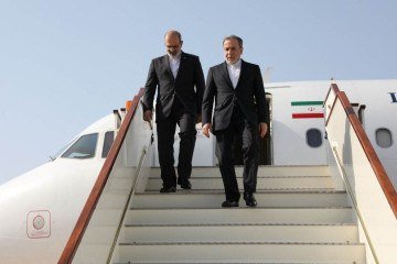 Ministro das Relações Exteriores do Irã, Abbas Araghchi (à direita), descendo as escadas de seu avião ao chegar a Mascate em 25 de abril de 2025 -  (crédito: Ministério das Relações Exteriores do Irã/AFP)