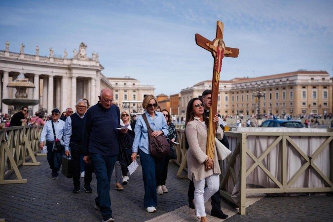Peregrinos caminham com cruz de madeira pela Praça de São Pedro: penitência, fé e esperança em um novo papa - (crédito: Dimitar Dilkoff/AFP) Peregrinos caminham com cruz de madeira pela Praça de São Pedro: penitência, fé e esperança em um novo papa - (crédito: Dimitar Dilkoff/AFP)