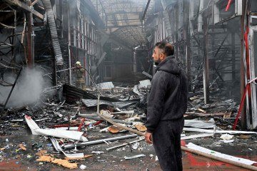 Um homem observa destroços mercado 'Barabashovo' após um ataque de drone em Kharkiv, em 6 de maio de 2025, em meio à invasão russa da Ucrânia.       -  (crédito: SERGEY BOBOK / AFP)