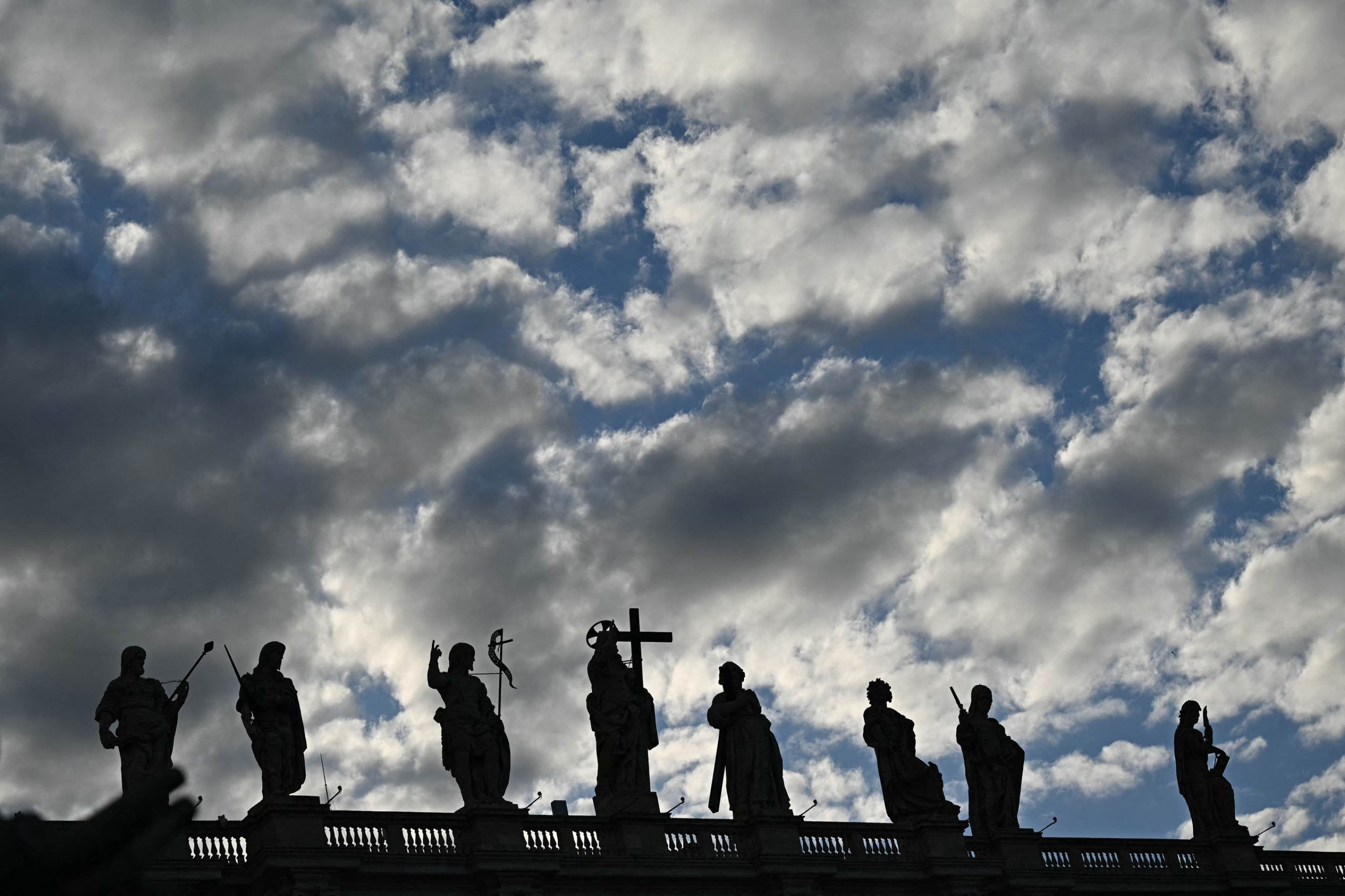  This photograph shows clouds and statues of the St Peters Basilica silhouhetted during the conclave in the Vatican on May 7, 2025. (Photo by Gabriel BOUYS / AFP)     