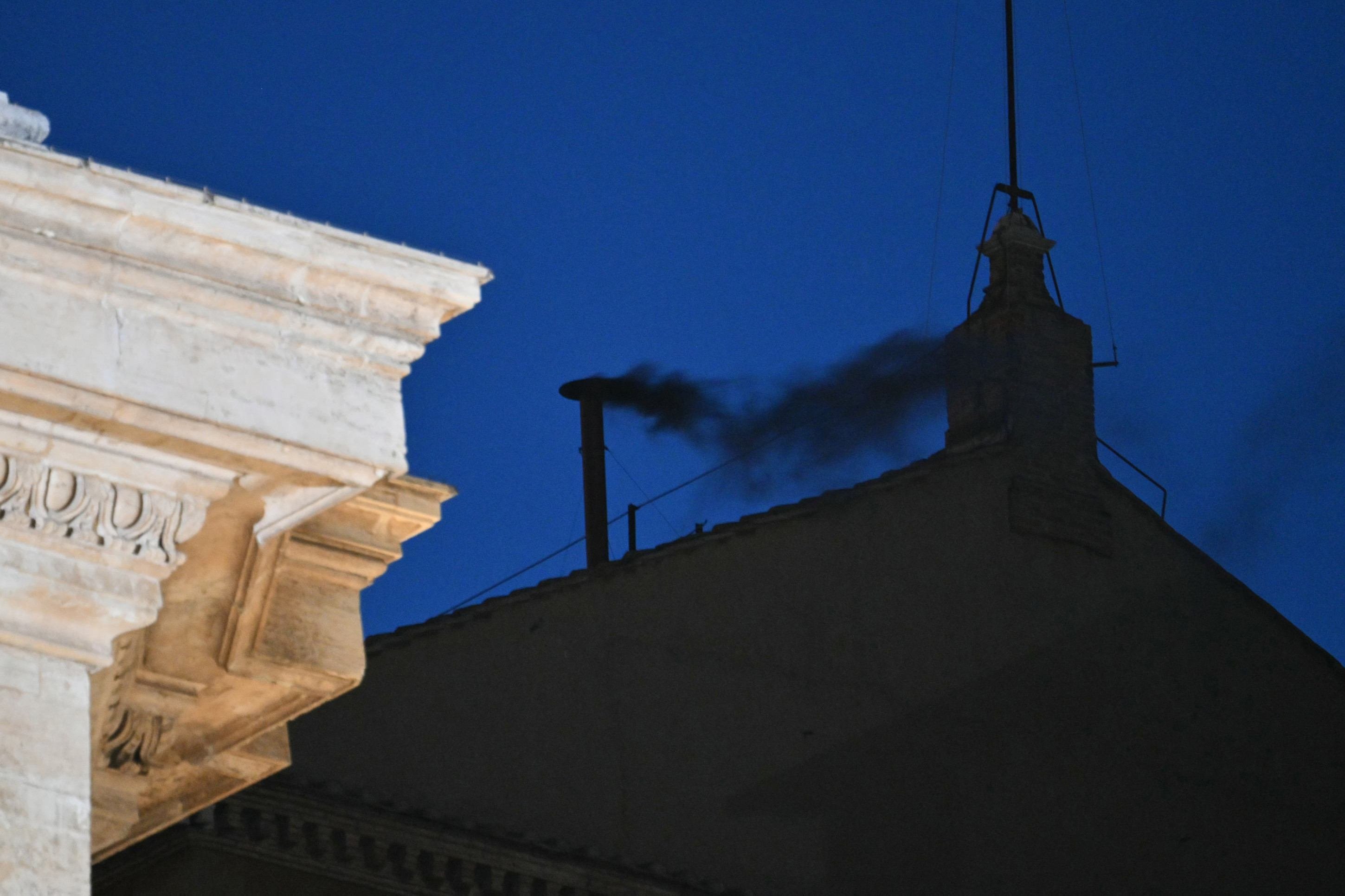  This photograph shows black smoke rising from the chimney of the Sistine Chapel signalling that cardinals failed to elect a new pope in the first ballot of their conclave in the Vatican on May 7, 2025. (Photo by Alberto PIZZOLI / AFP)     