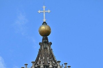 Visitantes são vistos no topo da cúpula da Basílica de São Pedro no segundo dia do conclave, no Vaticano, em 8 de maio de 2025       -  (crédito: Andreas SOLARO / AFP)
