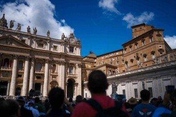 Pessoas na Praça de São Pedro após fumaça preta sair de uma chaminé sobre a Capela Sistina, no segundo dia do conclave, no Vaticano, em 8 de maio de 2025. Fumaça preta saiu de uma chaminé sobre a Capela Sistina do Vaticano pelo segundo dia em 8 de maio, enquanto os cardeais reunidos em conclave mais uma vez falharam em escolher um novo papa. Milhares de fiéis e curiosos aguardavam a fumaça na Praça de São Pedro na manhã do segundo dia de votação secreta dos 133 cardeais eleitores -  (crédito: Dimitar Dilkoff/AFP)