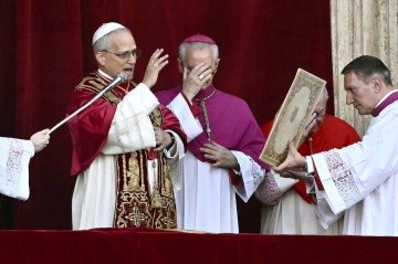 O recém-eleito Papa Leão XIV, Robert Prevost (E), discursa para a multidão na varanda principal da galeria central da Basílica de São Pedro pela primeira vez, após o encerramento do conclave pelos cardeais, no Vaticano, em 8 de maio de 2025. Robert Francis Prevost foi eleito na quinta-feira o primeiro papa dos Estados Unidos, anunciou o Vaticano. Moderado, próximo do Papa Francisco e missionário no Peru durante anos, ele se torna o 267º pontífice da Igreja Católica, adotando o nome papal de Leão XIV. -  (crédito: Filippo MONTEFORTE / AFP)