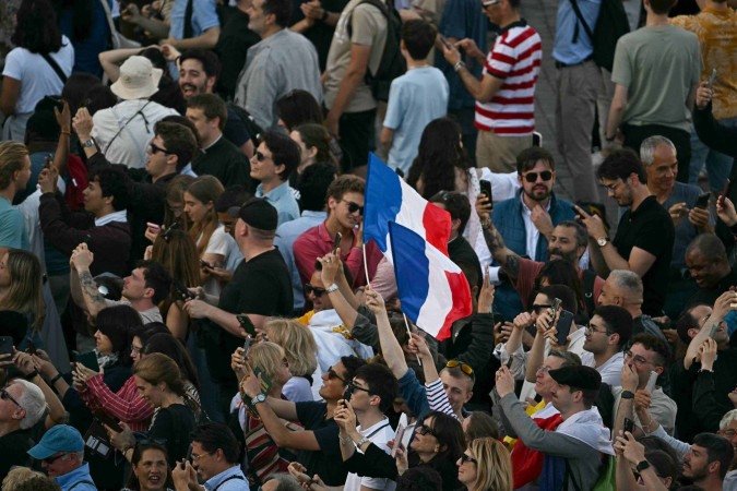 Pessoas reagem na Praça de São Pedro enquanto os cardeais sinalizam que elegeram um novo papa durante seu conclave secreto, no Vaticano, em 8 de maio de 2025.      