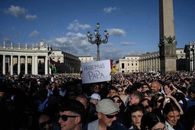Pessoas reagem na Praça de São Pedro enquanto os cardeais sinalizam que elegeram um novo papa durante seu conclave secreto, no Vaticano, em 8 de maio de 2025.      