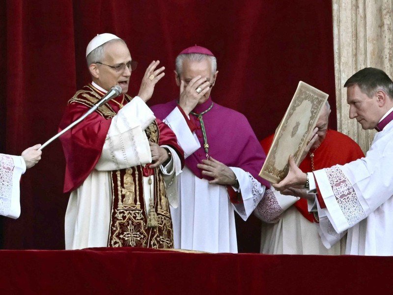 O recém-eleito Papa Leão XIV, Robert Prevost (E), discursa para a multidão na varanda principal da galeria central da Basílica de São Pedro pela primeira vez, após o encerramento do conclave pelos cardeais, no Vaticano, em 8 de maio de 2025. Robert Francis Prevost foi eleito na quinta-feira o primeiro papa dos Estados Unidos, anunciou o Vaticano. Moderado, próximo do Papa Francisco e missionário no Peru durante anos, ele se torna o 267º pontífice da Igreja Católica, adotando o nome papal de Leão XIV. -  (crédito: Filippo MONTEFORTE / AFP)