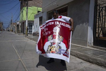 Homem exibe cartaz em homenagem a Prevost em Eten    