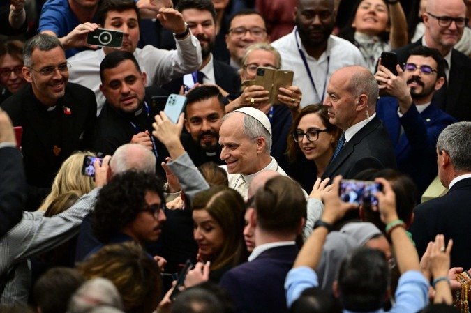  Pope Leo XIV (C) meets with journalists using smartphones during an audience to representatives of the media, at Paul-VI hall in The Vatican, on May 12, 2025. (Photo by Tiziana FABI / AFP)
      
